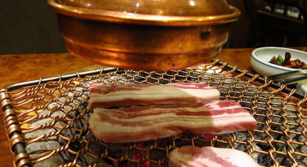 Thick samgyeopsal on a charcoal grill