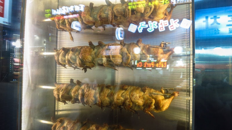 Chickens being roasted at the front of the restaurant 
