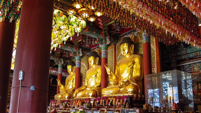 Amitabha Buddha, Shakyamuni Buddha, and Bhaisajya Buddha statues inside Daeungjeon Hall
