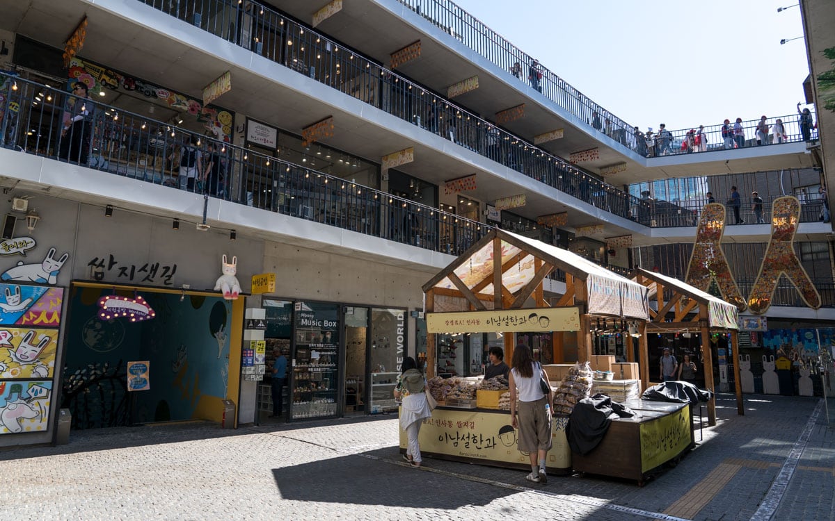 Open courtyard inside Ssamzigil Market in Seoul with shops, walkways, and a food stall